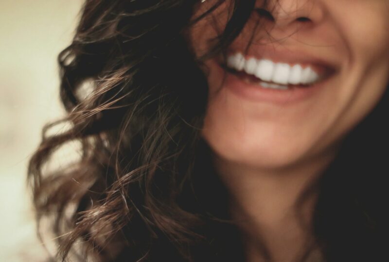 Nasmijana žena duge tamne kose, izbliza