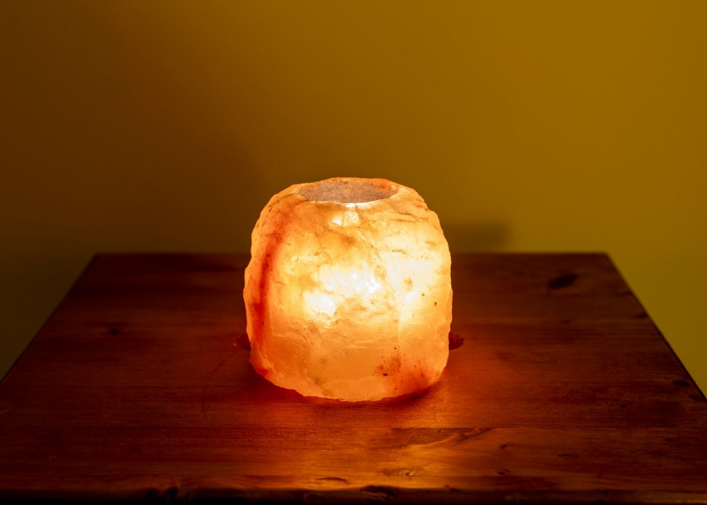 Upaljena lampa od kamene soli na drvenom stolu
