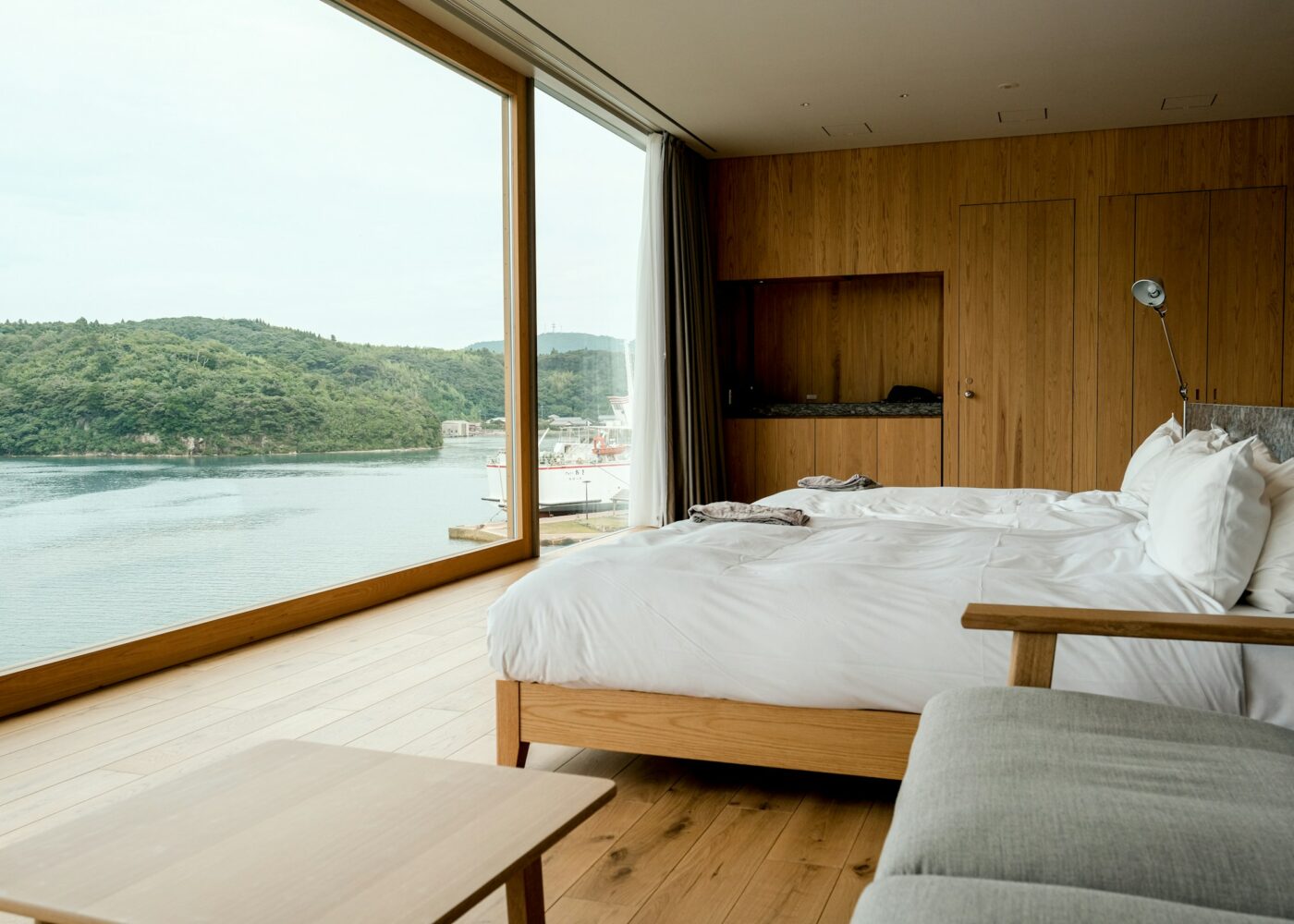 Svijetla hotelska soba s bijelim krevetom i pogledom na more